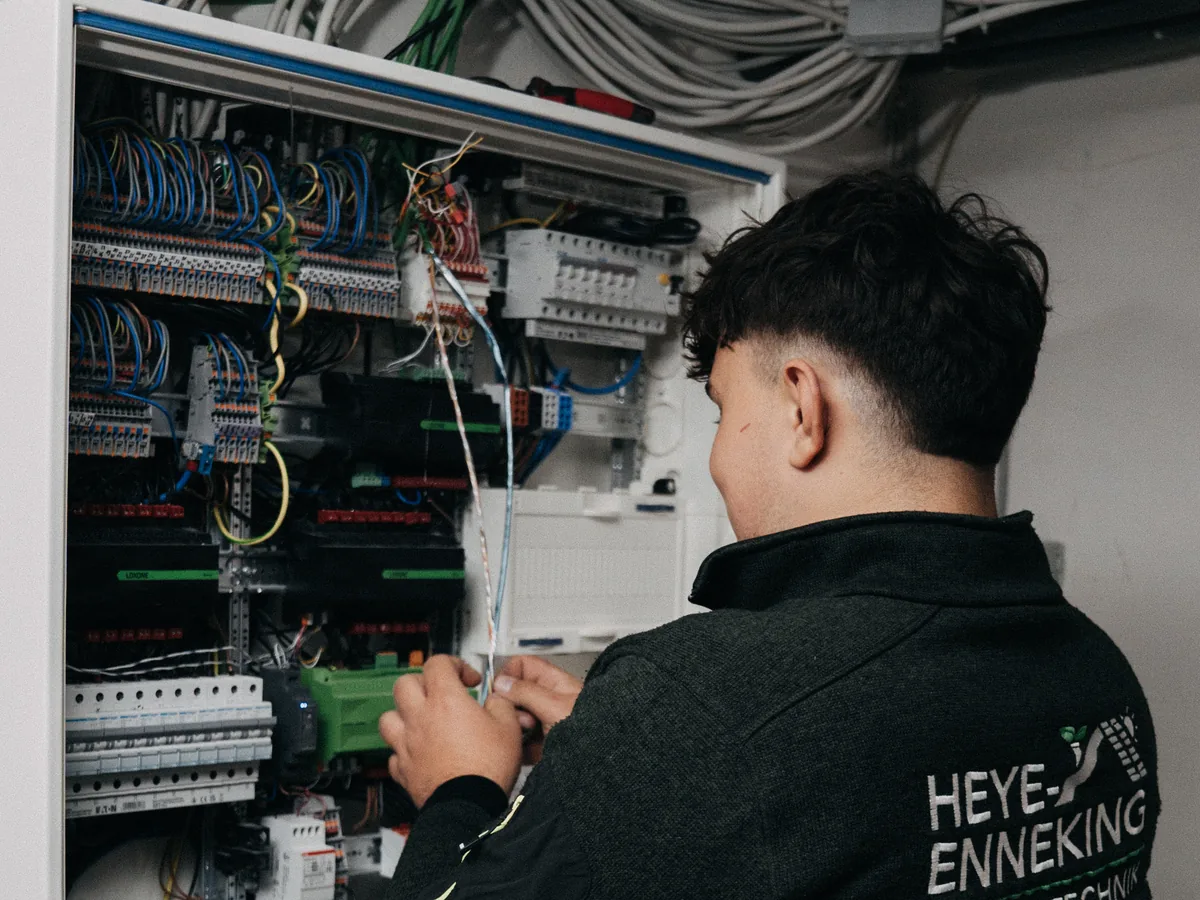 Elektriker von Heye-Enneking verdrahtet einen Smart-Home-Schaltschrank mit Loxone-Steuerung